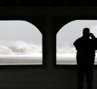 A person takes a photograph of the rough Atlantic Ocean from a pavilion in Cape May, N.J., on Monday.  