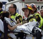 Emergency responders comfort a woman on a stretcher who was injured in a bomb blast near the finish line of the Boston Marathon on Monday. Photo by By The Associated Press