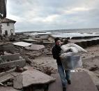 Peter Andrews removes belongings from his father's beachfront home, destroyed in the aftermath of a storm surge from the superstorm Sandy, Tuesday, in Coney Island's Sea Gate community in New York. Andrews, 40, who was born in the house, said "we had a lot of storms and the only damage in the past was when a national guardsman threw a sandbag through the window."  He added, the house was in the process of being sold. Photo by Bebeto Matthews