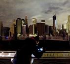 A woman photographs the Manhattan skyline, Tuesday, in New York. Much of lower Manhattan is without electric power following the impact of superstorm Sandy. Photo by Mark Lennihan