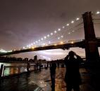 People photograph the Brooklyn Bridge and the Manhattan skyline, Tuesday, in New York. Much of lower Manhattan is without electric power following the impact of superstorm Sandy. Photo by Mark Lennihan
