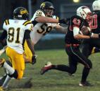 Snider’s Quinton Daniels and Andrew Meyers go after North Side’s Josh Fleming in the first quarter of Friday night’s game at North Side. Snider beat North side 17-6. (By Ellie Bogue of The News-Sentinel)