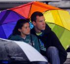 A young couple share an umbrella during avery wet night of Football at Garrett High School Friday night. Garrrett beat Leo, 20-6. (By Ellie Bogue of The News-Sentinel)