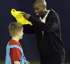 Ten-year old Ian, left, receives a yellow jersey in place of a yellow card as a joke from DaMarcus Beasley after making contact with another player during Tuesday's session at the Beasley National Soccer School holiday camp at The Plex South.